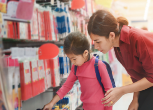 how to make sustainable choices for back to school - mother and daughter selecting school supplies in store