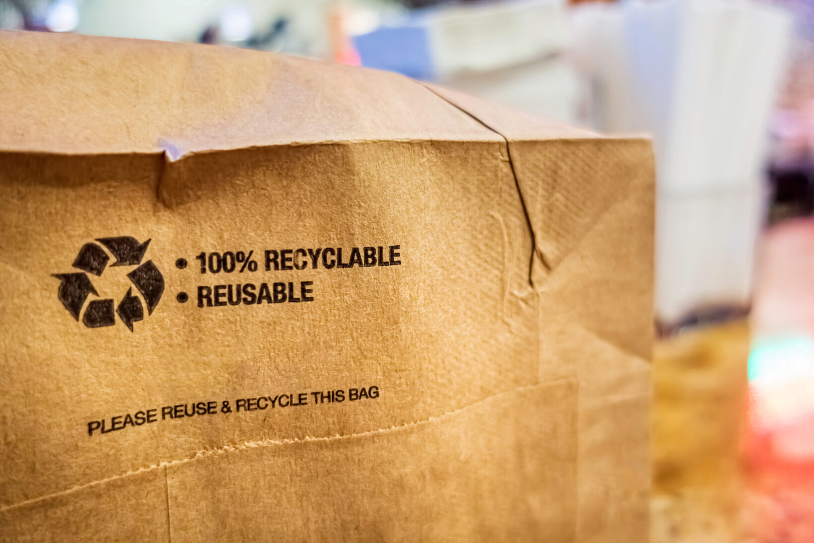 Image: Bottom of brown paper bag with recycling symbol and words 100% recyclable and reusable. The FTC Green Guides help ensure accuracy of environmental claims. Learn what Domtar and our industry are suggesting for the updated guide.