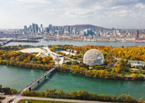 View of Montreal biodome and skyline from across the St. Lawrence River, with Mont Royal in the background. The photo was taken in the autumn with colorful leaves. Montreal is the host city for PaperWeek Canada, Feb. 5-8, where Paper Excellence Group leaders are presenting.