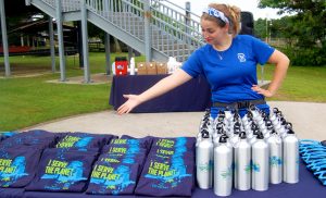 A Plymouth Project participant displays shirts an water bottles to be handed out later in the day.