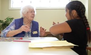 Kamloops PaperPals Meet - An elderly woman talks with a young girl