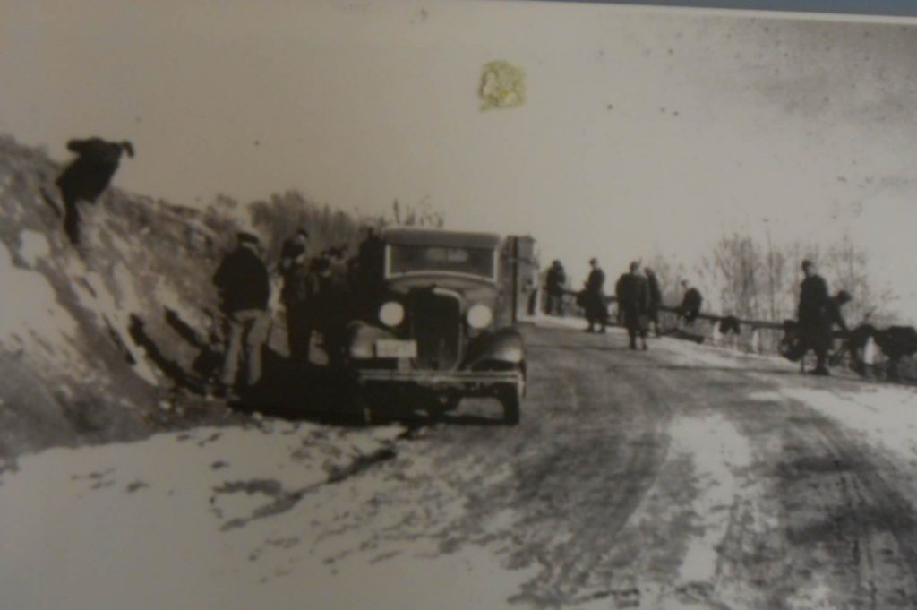 German POWs working on a highway next to a car