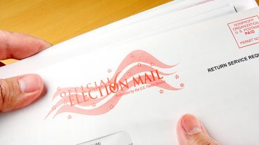 hands holding a mail-in ballot