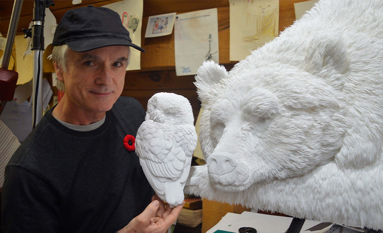 paper artist Calvin Nicholls with two of his works
