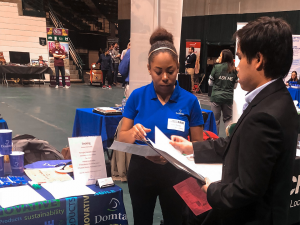 Talia Massey talks with a student at a college career fair in 2018. (Photo taken prior to COVID-19 pandemic.)