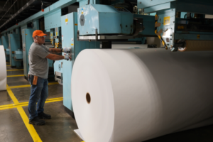 United Steelworkers union member standing next to a roll of paper
