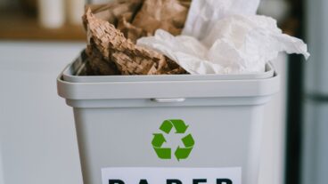 Image: Grey recycling bin in office environment, labeled 